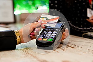 Young woman paying by credit card in clothing store , closeup