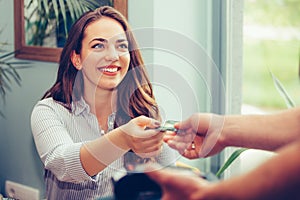 Young woman is paying with a credit card for lunch at the restaurant