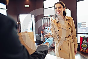 Young woman paying credit card for purchases in grocery store.