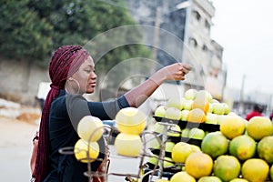 Young woman paying fruits at street market.