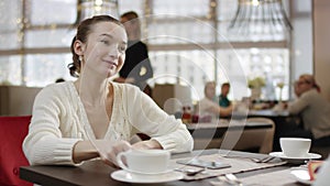 Young woman paying for lunch in a cafe with a credit card