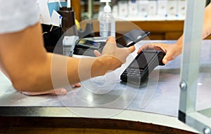 Young woman paying with mobile in a store