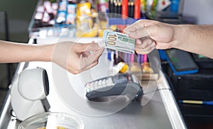 Young woman paying money in supermarket