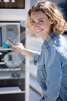 young woman paying for parking at pay station