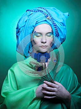 Young woman with peacock feathers
