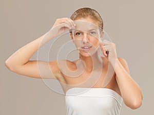 Young woman peeling off a facial mask smiling