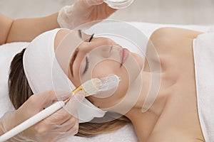 Young woman during peeling procedure in salon