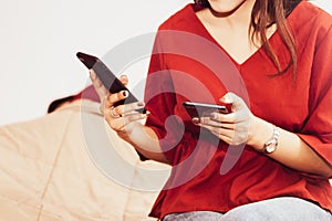 young woman peeps on her phone to investigate her husband`s behavior to find secrets and suspect something.