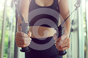 Young woman with perfect body training triceps with cable exercise machine in the gym. Concept fitness ,workout, gym exercise ,