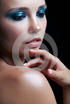 Young woman with perfect skin and blue-green smoky eyes eye shad