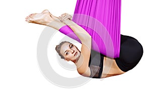 Young woman performing antigravity yoga exercise