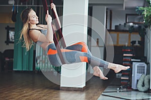 Young woman performing antigravity yoga exercise