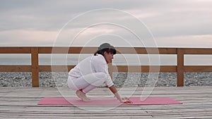 Young woman is performing handstand in yoga class outdoors