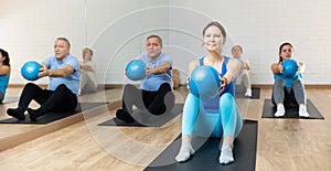 Young woman performing sit-up with bender ball in fitness studio