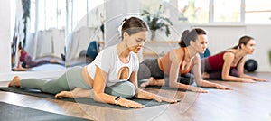 Young woman performing sleeping pigeon pose Kapotasana at yoga training