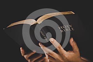 Young woman person hand holding holy bible with study at home. Adult female christian reading book in church. Girl learning