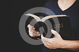 Young woman person hand holding holy bible with study at home. Adult female christian reading book in church. Girl learning