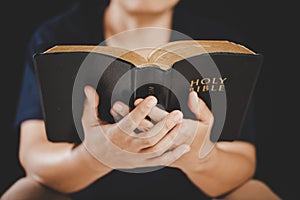 Young woman person hand holding holy bible with study at home. Adult female christian reading book in church. Girl learning