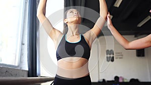 Young woman personal trainer helping with workout at gym