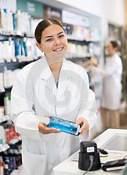 Young woman pharmacist scanning cosmetics at checkout