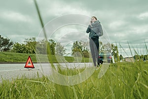 Young woman is on the phone with a car breakdown