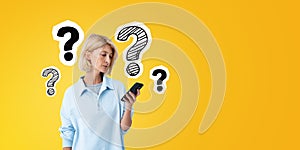 Young woman with phone in hand, question marks sketch on empty background