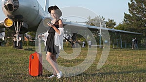 young woman with a phone in her hands on the background of the plane. vacation concept. Portrait of a beautiful woman at