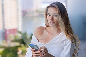 Young woman with phone, isolated on balcony terrace. Business woman using smartphone. Business talk. Girl using phone