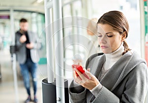 Young woman with phone in public transport