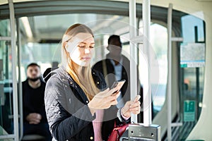 Young woman with phone in streetcar