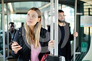 Young woman with phone in streetcar