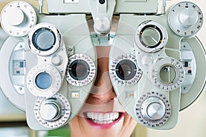 Young woman at phoropter for eye test