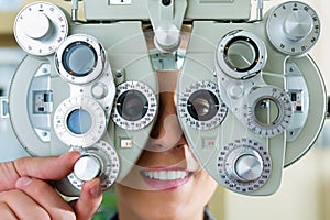 Young woman at phoropter for eye test