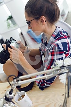 Young woman photographer checking previews on camera in the stud