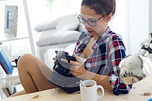 Young woman photographer checking previews on camera in the stud