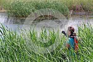 Young woman photographer in delta. Vacaresti Nature Park - landmark attraction in Bucharest, Romania