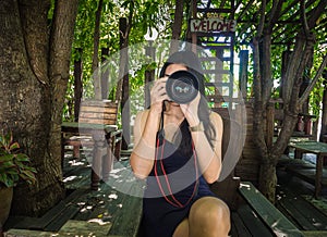 Young woman photographer taking picture in the cafe