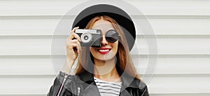 young woman photographer with vintage film camera on a white background