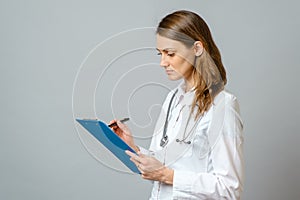 Young woman physician with stethoscope prescribing treatment to patient