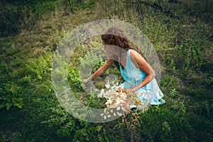 Young woman pick herbs and flowers on clean wild mountain meado