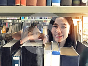 Young woman picking a book off the shelf in a library