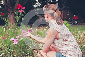 Young woman picking flowers in meadow