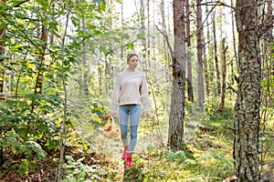 Young woman picking mushrooms in autumn forest