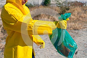 Young woman picking up garbage in the forest in the morning. Environmental plastic pollution. Voluntary ecological concept