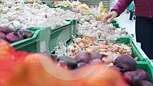 Young Woman Picking Up Garlic for Purchase