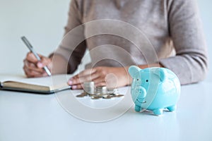 Young woman and piggy bank to planning growing saving strategy with pile coins for future plan fund of travel, education, home and