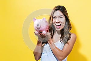 Young woman with a piggy bank