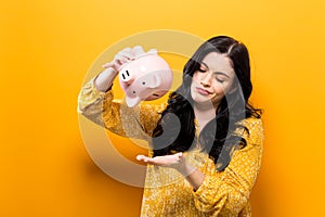 Young woman with a piggy bank