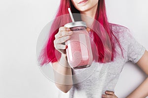 Young woman with pink hair drinks smoothies from berries and fruits. Concept meals to go