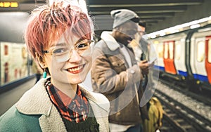 Young woman with pink hair and group of multiracial hipster friends at subway station